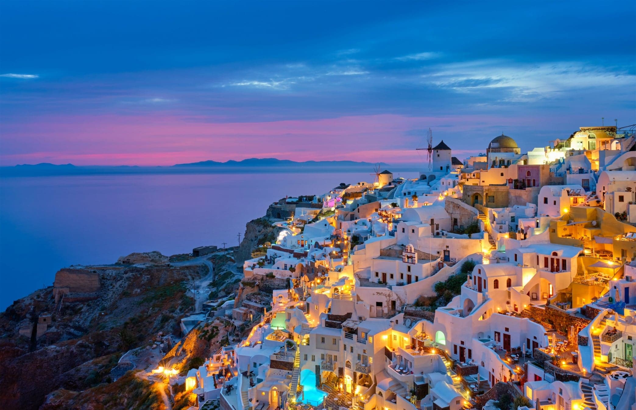 Whitewashed cliffside village in Santorini at dusk overlooking the sea